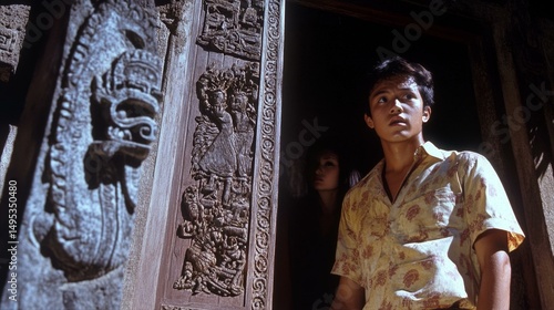Young Man Emerges from Ornate Doorway Featuring Intricate Carvings with Woman in Shadowy Background