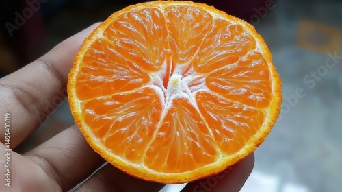 Eating An Orange. Hand holding Mandarin Citrous Fruit for Healthy Eating
