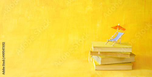 Obraz na plátně stack of books with deckchair and sun umbrella, spring and summer holiday read