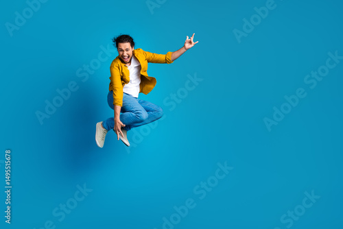 Wallpaper Mural Energetic man in yellow shirt with dynamic pose on blue background showing enthusiasm and cheerful attitude to life Torontodigital.ca
