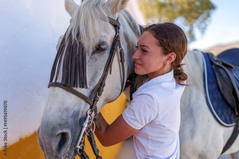 Obraz premium Warmhearted young rider embracing white horse affectionately inside wooden stable before equestrian event