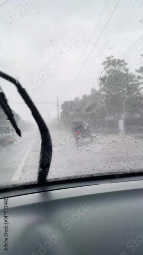 car driving on the road in a storm, windshield wipers clearing the glass from heavy rain, view from inside the car
