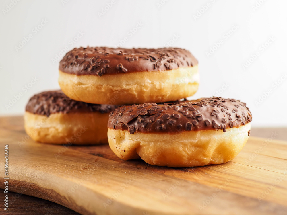 Sweet tasty chocolate donuts on wooden board. Popular desert and snack. Fine bakery product. Sweet tasty chocolate donuts on wooden board. Popular desert and snack. Fine bakery product.