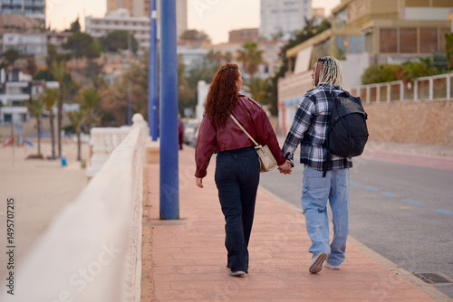 Wallpaper Mural Couples enjoy a romantic stroll along the beach at sunset in a coastal town Torontodigital.ca
