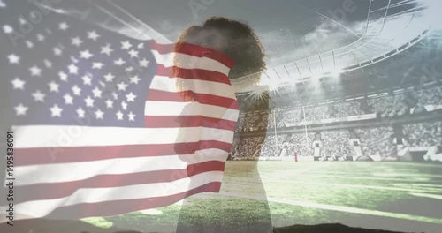 Flag billowing revealing woman singing national anthem in sports stadium under floodlights
