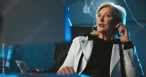 Night, hacker and phone call at computer for cyber crime, negotiation or contact for scam. Mature woman, team and underground with technology for data phishing, blackmail threat or ransomware in dark