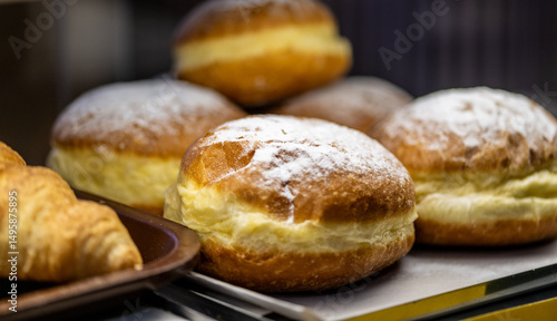 Wallpaper Mural Traditional European cream-filled pastries dusted with powdered sugar displayed alongside golden croissants on bakery shelf, macro food photography Torontodigital.ca