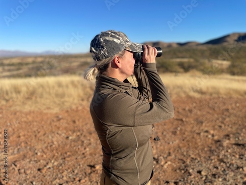 woman in mountains with binoculars hunting and hiking