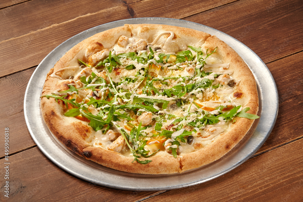 Delicious pizza with chicken, arugula, and parmesan cheese on wooden table Delicious pizza with chicken, arugula, and parmesan cheese on wooden table