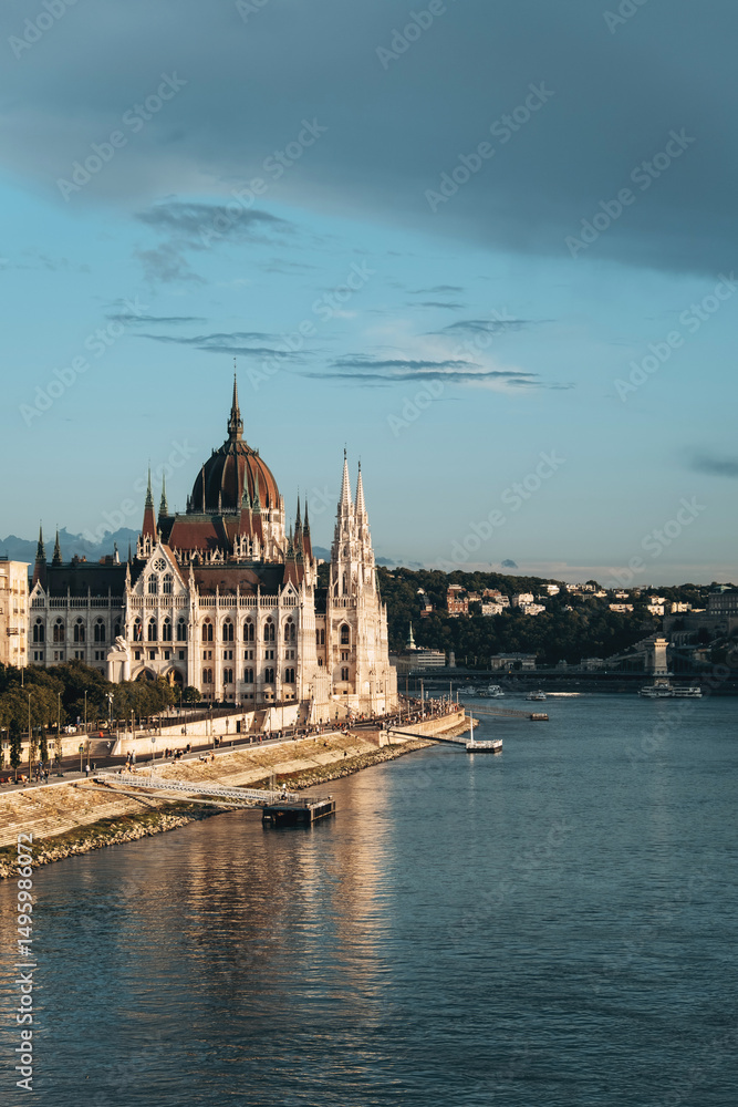 Fototapeta premium The Hungarian Parliament Building and the Danube River at sunset, Budapest, Hungary. Vertical photo