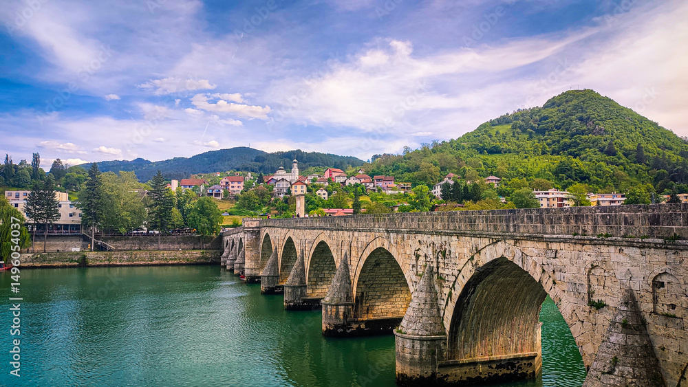 Fototapeta premium Ancient stone bridge on the Drina River. The famous historical bridge on the Drina River, built in 1571. by Mehmed Pasa Sokolovic in the city of Visegrad, Bosnia and Herzegovina.