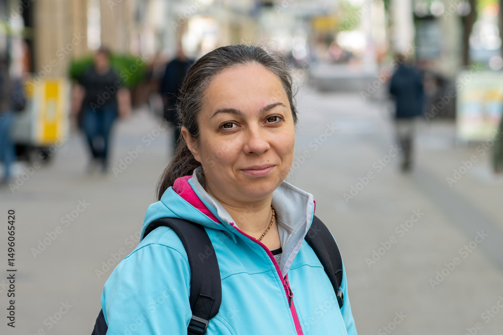 A confident adult woman with a backpack looking at the camera - the concept of urban mobility. A confident adult woman with a backpack looking at the camera - the concept of urban mobility.
