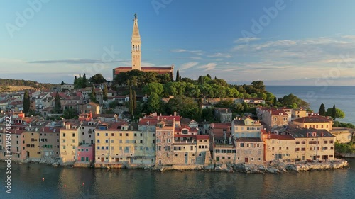 Fly near coastal town of Rovinj in Croatia during sunset. Sunset aerial shot of old town Rovinj, famous ancient Croatian city at the sea. Istria, Croatia