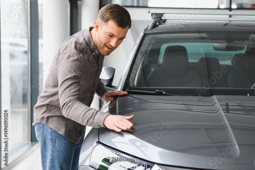 Картината върху платно Man inspecting new car in showroom setting