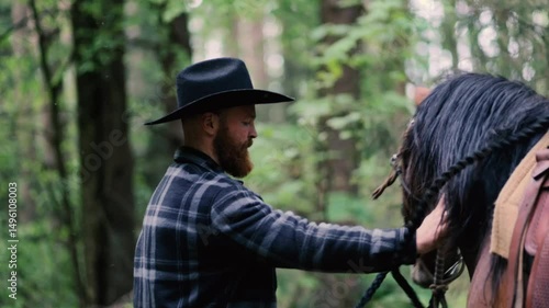 cowboy in hat with beard with horse in nature