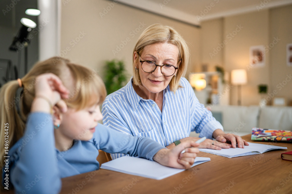 Grandmother help granddaughter do school homework together at home Grandmother help granddaughter do school homework together at home
