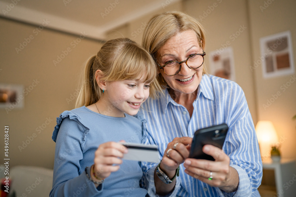 grandma and granddaughter have online shopping in the living room grandma and granddaughter have online shopping in the living room