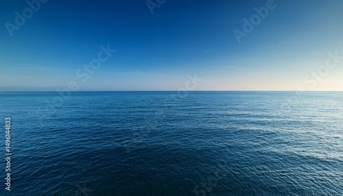 serene ocean view under a clear blue sky capturing tranquility and vastness at sunrise