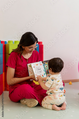 Pediatrician reading a book to baby girl in doctor's office