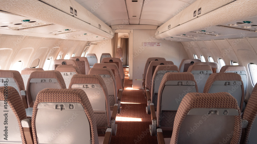 Fototapeta premium The cabin of a vintage Soviet aircraft boasts neatly arranged seats and soft lighting, showcasing classic USSR aviation design.