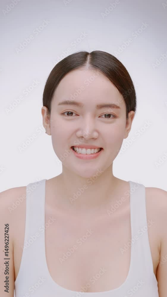 Vertical clip. Portrait of a young Asian girl with light makeup and perfect skin. Beautiful face of young woman with natural skin. Vertical clip. Portrait of a young Asian girl with light makeup and perfect skin. Beautiful face of young woman with natural skin.
