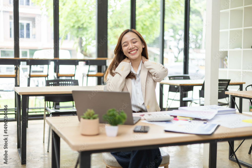 A woman is working at a desk in an office with a laptop, a mobile phone and a pile of documents. She is smiling and happy.
A woman is working at a desk in an office with a laptop, a mobile phone and a pile of documents. She is smiling and happy.