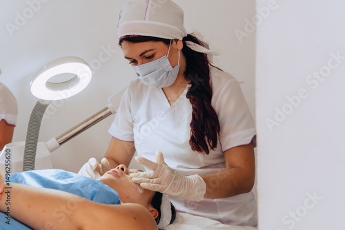 Obraz na plátně Copy-spaced photo of a young mestiza Colombian woman at a beauty spa having sunscreen applied to her face to complete a facial cleansing treatment