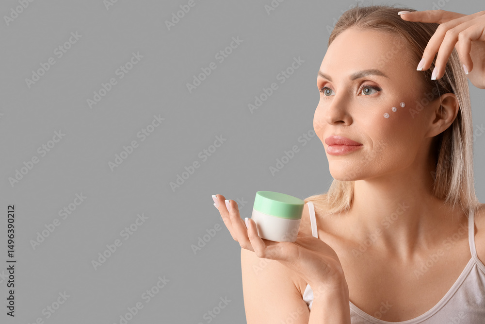 Beautiful woman with cream on grey background, closeup Beautiful woman with cream on grey background, closeup