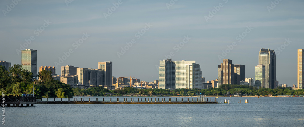 Naklejka premium Captivating City Skyline Reflected in Serene Waters at Dawn