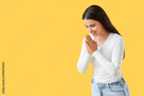 Thankful young woman on yel...
