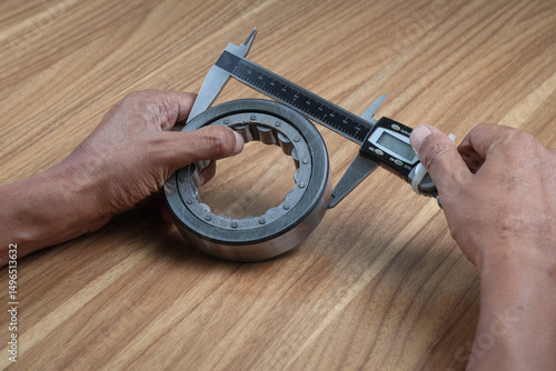 Worker is measuring outside diameter of bearing with a digital vernier caliper micrometer. Micrometer, sometimes known as a micrometer screw gauge, is a device incorporating a calibrated screw.
