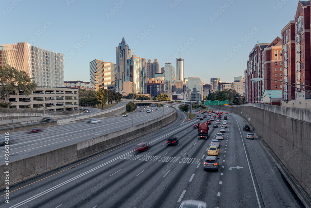 Obraz premium Downtown Atlanta Skyline showing several prominent buildings, highways, cars and hotels under a golden hour sunset.
