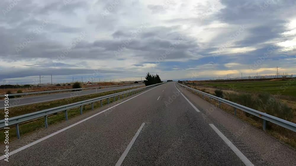 Empty highway under cloudy sky with guardrails Empty highway under cloudy sky with guardrails