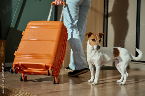 Foto Woman leaving home with dog and suitcase