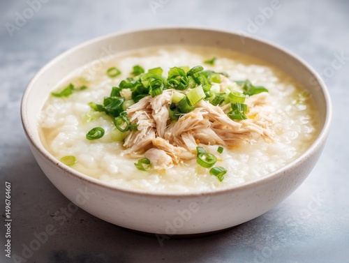Bowl of chicken congee with shredded chicken and green onions, comforting Asian dish