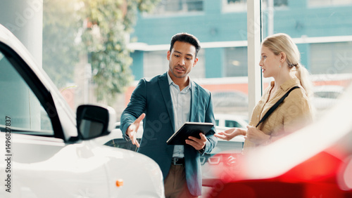 Tablet, customer and salesman with talking for car dealership, transport model and motor for rental service. Showroom, woman and male seller with tech for assistance, vehicle features and discussion