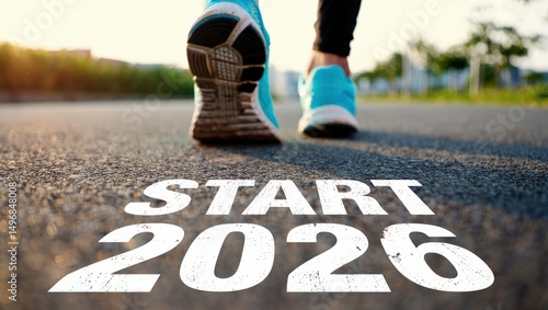 Wallpaper Mural Low-angle close-up of neon blue running shoes on asphalt with "START 2026" text, bathed in golden hour light. Torontodigital.ca