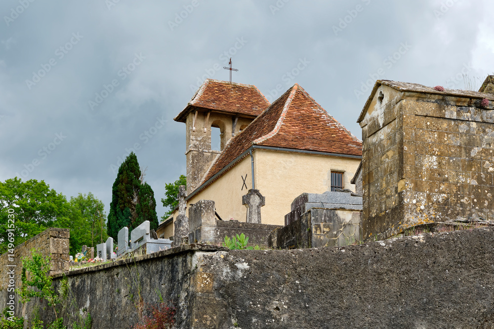 Fototapeta premium View of the White Penitents Chapel and cemetery on a hill near the village of Cornac Lot Occitanie in Southern France in summer under a cloudy sky 