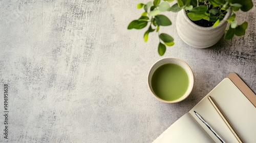 Minimalist flat lay with eucalyptus plant, ceramic teacup of matcha green tea, notebook and pen on white textured surface, calm aesthetic for wellness, creativity, relaxation, journaling