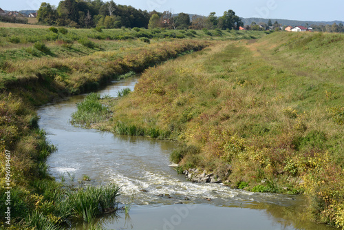 Fototapeta Naklejka Na Ścianę i Meble -  The Cesma River meanders westward through a grassy, rural landscape near Cazma