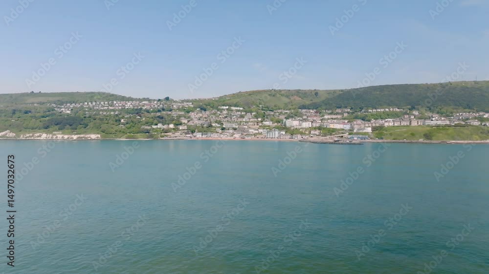 A beautiful blue ocean with a small town in the background. The water A beautiful blue ocean with a small town in the background. The water