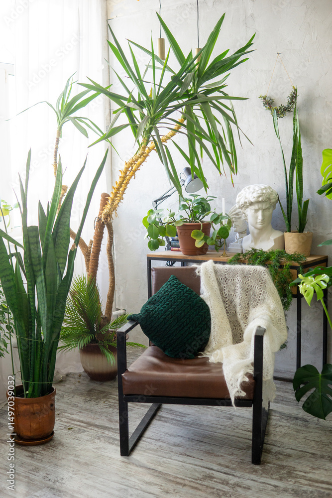 Obraz premium A fragment of the interior with a variety of indoor plants and plaster sculptures. Urban jungle concept. Biophilia design.