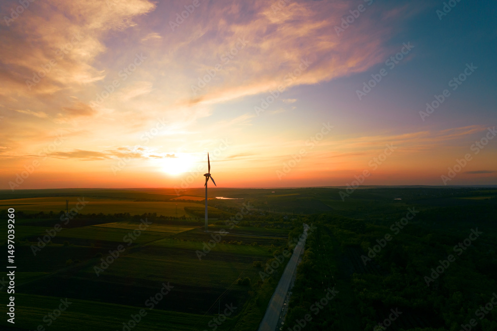 Obraz premium Aerial view of windmill turbines generating green energy electricity at sunset.Green energy helps reduce carbon emissions and makes the earth cleaner and more ecological.Ecology technology industrial.