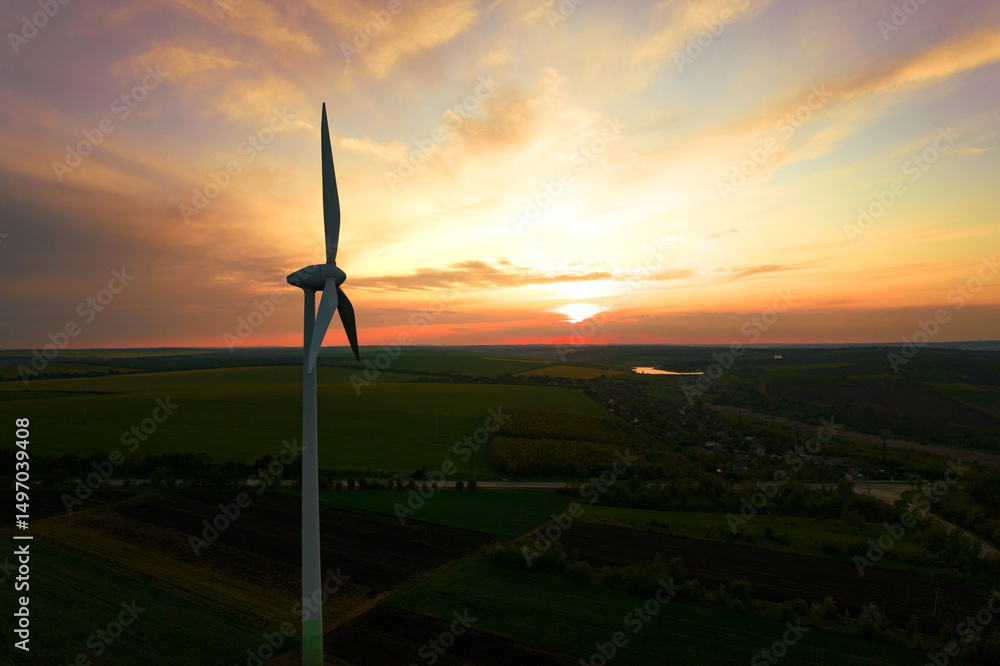 Obraz premium Aerial view of windmill turbines generating green energy electricity at sunset.Green energy helps reduce carbon emissions and makes the earth cleaner and more ecological.Ecology technology industrial.