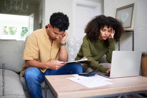 Valokuva Focused Couple Reviewing Financial Documents and Using a Laptop Together at Home