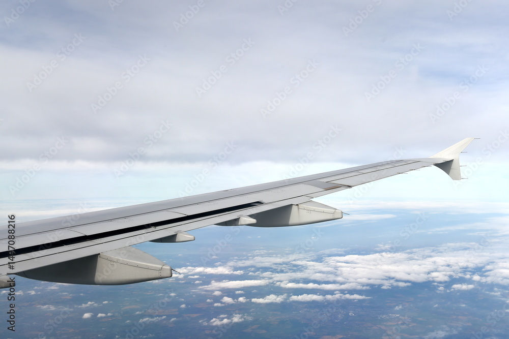Fototapeta premium View of an airplane wing against a cloudy sky