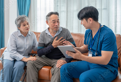scene of senior patient talking to a visiting nurse who using tablet computer giving advice elderly man and family for self health care at home
