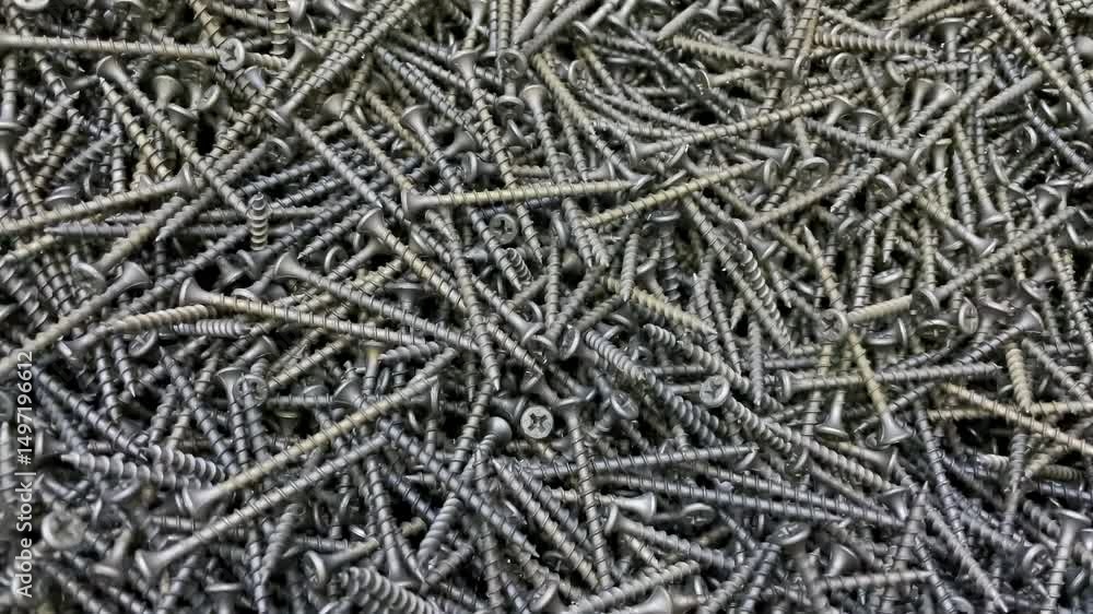 Top-Down View Of A Pile Of Steel Screws In Motion, Highlighting Their Texture And Use In Construction And Repair. Top-Down View Of A Pile Of Steel Screws In Motion, Highlighting Their Texture And Use In Construction And Repair.
