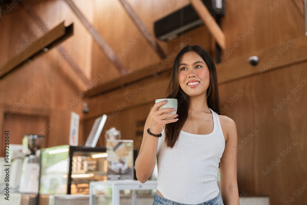 young woman in cafe holding coffee cup young woman in cafe holding coffee cup
