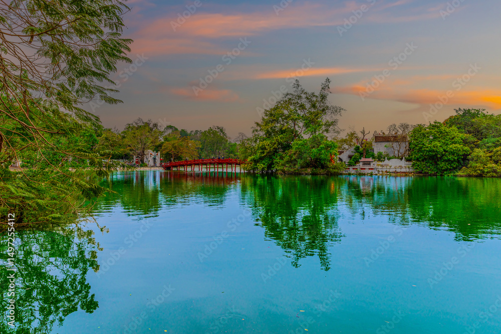 Obraz premium Lake in Hanoi Old Commercial Shops and Apartment house block in Hanoi Old Quarters Vietnam. Trees red bridge and green Pond 